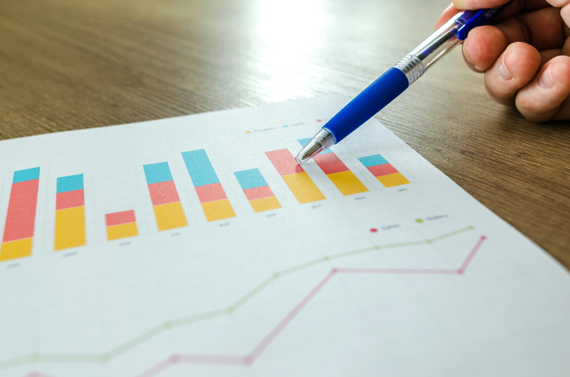  person holding pen pointing at graph 
