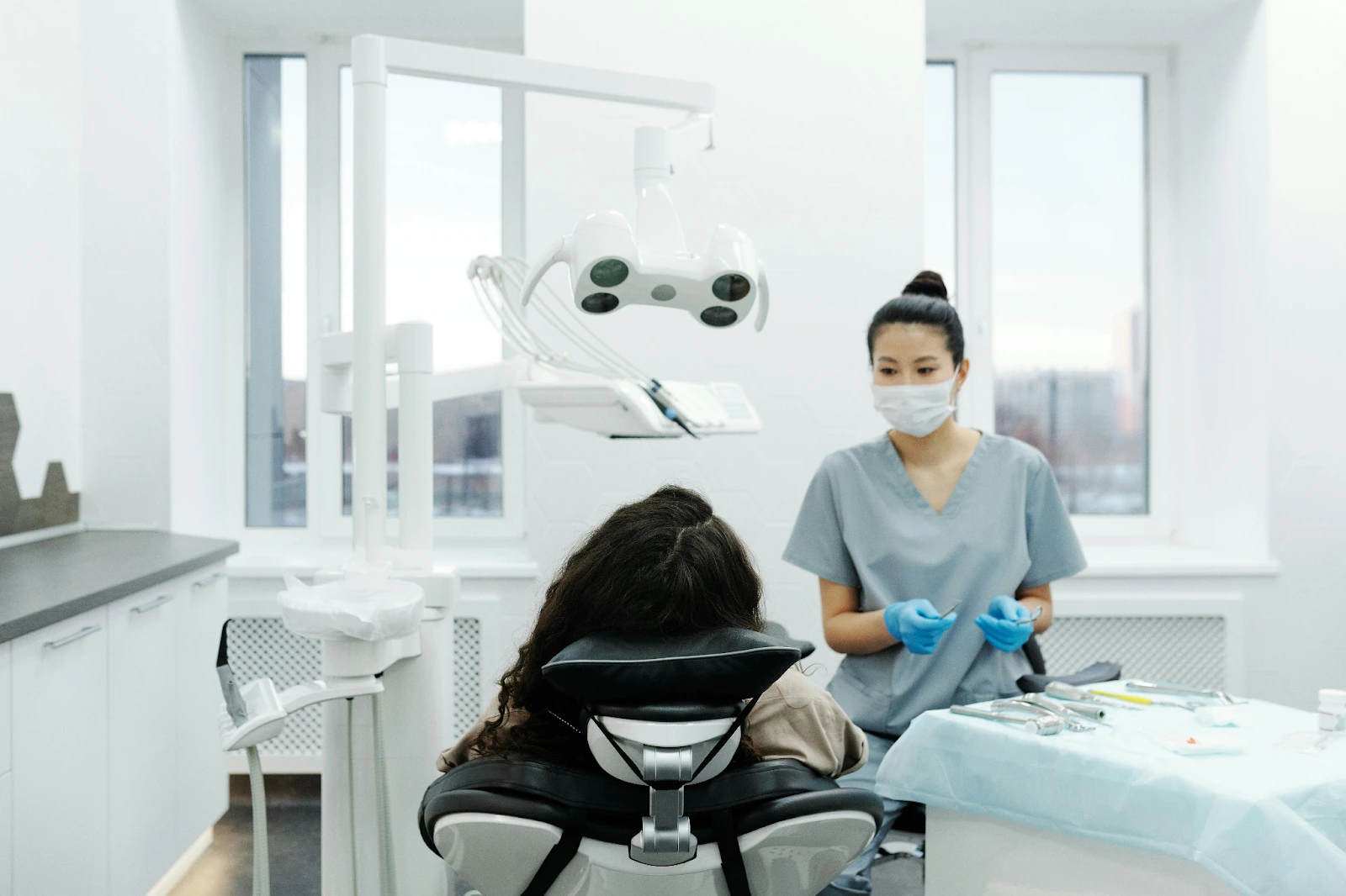 A female doctor looking at a patient lying on a chair