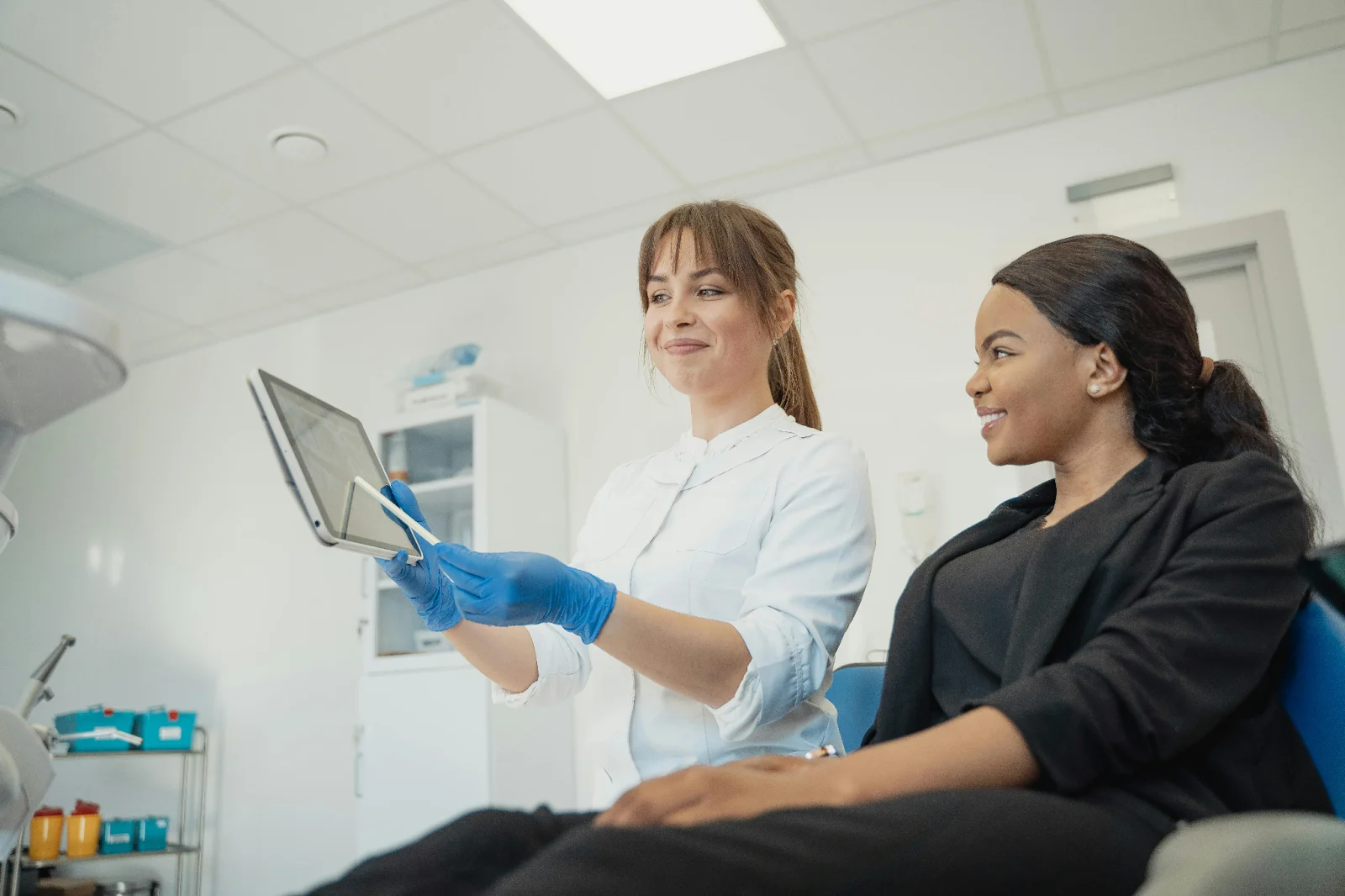 A dental professional showing reports to a patient on a tablet